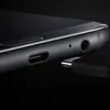 A close-up shot of the bottom edge of a black smartphone, showing the USB-C port and headphone jack, with a USB-C cable partially inserted into the port. Náhľad obrázku produktu