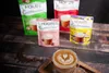 Several pouches of Mokate Cappuccino are arranged behind a cup of cappuccino with latte art, on a wooden surface. Anteprima dell’immagine prodotto