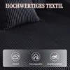 A close-up view of a black corduroy sofa with text overlays highlighting its features. Voir les images du produit