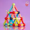A pyramid-shaped structure built from colorful magnetic building rods and balls, set against a purple background with small lightning bolt graphics and a horseshoe magnet icon. Náhled obrázku produktu