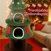 A Christmas-themed cat tree is shown in a cozy living room setting with a fireplace and sofa in the background. Anteprima dell’immagine prodotto