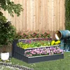 A tiered garden bed filled with colorful flowers, set against a wooden fence with some old barrels in the background. Podgląd zdjęcia produktu