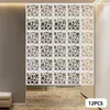 A room divider made of white, square panels with circular cutouts, installed in a room. Náhled obrázku produktu