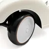 A close-up view of a retro-style baby product's wheel and fender. Produktbild-Vorschau