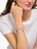 A woman's arm wearing a charm bracelet with colorful gummy bear charms. Anteprima dell’immagine prodotto