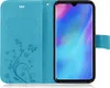 A blue flip cover phone case with a floral and butterfly design, open to reveal a smartphone inside. Produktbild-Vorschau