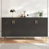A dark gray sideboard with gold handles and legs, decorated with arched patterns, is placed on a wooden floor in front of a white wall. Decorative items are placed on top of the sideboard. Produktbild-Vorschau