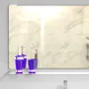 A bathroom shelf with a soap dispenser and a cup reflected in a mirror. Anteprima dell’immagine prodotto