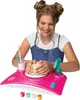 A young girl is using a pottery wheel toy. Produktbild-Vorschau