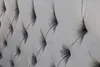 A close-up view of a tufted grey velvet fabric, likely a headboard or upholstered furniture. Náhled obrázku produktu