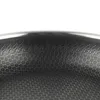 A close-up view of the textured interior of a frying pan, showing a honeycomb pattern and a decorative border. Podgląd zdjęcia produktu