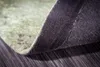A close-up view of the underside of a rug, showing the texture of the backing material and the edge of the rug's top surface. Produktbild-Vorschau