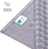 A close-up view of a folded textile product with a label and text indicating it has been tested for harmful substances. Anteprima dell’immagine prodotto