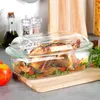 A roasted chicken with vegetables in a glass baking dish on a wooden cutting board. Anteprima dell’immagine prodotto