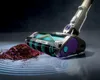 A close-up of a vacuum cleaner head cleaning up a pile of dirt, with light effects indicating its function. Anteprima dell’immagine prodotto