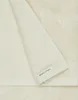 A close-up view of a folded towel, showing its texture and a brand label. Produktbild-Vorschau