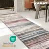 A runner rug with a striped pattern lies on a concrete floor next to a dining table and chairs. Náhled obrázku produktu