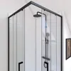 A modern corner shower cabin with a black aluminum frame and clear glass doors, featuring a black shower head and controls against a white tiled wall. Náhľad obrázku produktu