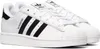 A pair of white Adidas Superstar sneakers with black stripes. Voir les images du produit