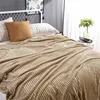A bed with a textured beige blanket and pillows. Produktbild-Vorschau