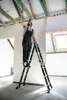 A man is working on the ceiling of a room under construction, standing on a multi-purpose ladder. Náhľad obrázku produktu