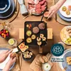 A group of people enjoying a raclette meal around a table. Produktbild-Vorschau