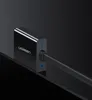 A close-up shot of a black Ugreen HDMI to VGA converter with a cable plugged in, resting on a dark surface. Voir les images du produit