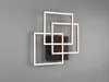 A modern, geometric LED wall light with three overlapping square frames, mounted on a dark rectangular base against a plain gray wall. Náhľad obrázku produktu