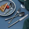 A slice of cake and cutlery are arranged on a blue plate and blue surface. Podgląd zdjęcia produktu