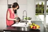 A woman is washing dishes in a modern kitchen. Podgląd zdjęcia produktu