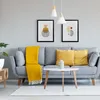 A living room scene with a gray sofa, yellow throw pillows, and a yellow blanket. Produktbild-Vorschau