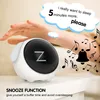 A hand is reaching out towards a digital alarm clock with a sleepy face on its screen. Musical notes and a bell graphic surround the clock, suggesting an alarm sound. Text overlays describe the snooze function. Produktbild-Vorschau