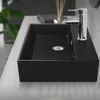 A black ceramic sink with a chrome faucet on a light-colored countertop. Podgląd zdjęcia produktu