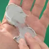 A close-up of a hand holding a dollop of light gray modeling paste. Podgląd zdjęcia produktu