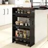 A black four-tier rolling cart filled with jars and bottles, placed next to a kitchen island. Podgląd zdjęcia produktu
