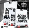 Three bags of BLADE SERIES 100% Whey Mass Gainer are displayed in front of a blurred background of gym equipment. Produktbild-Vorschau