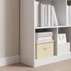 A close-up view of a white bookshelf with books and a storage box. Podgląd zdjęcia produktu