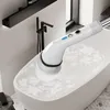A white electric cleaning brush with a telescopic handle is being used to scrub a bathtub filled with water and bubbles. Voir les images du produit