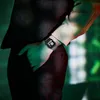 A person wearing a suit and a watch, with dramatic lighting. Voir les images du produit