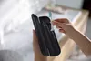 A person is holding an electric toothbrush and its case. Produktbild-Vorschau