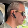 A man wearing sunglasses and a Bluetooth headset in a car. Náhled obrázku produktu