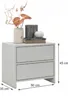 A white nightstand with two drawers, decorated with a vase of flowers and books. Voir les images du produit