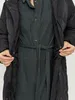 A person wearing a black puffer coat and a dark green dress is shown from the chest down, with their hands holding the zippers of the coat. Produktbild-Vorschau
