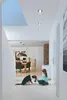 A girl plays with her dog in a hallway, with a dining area visible in the background. Voir les images du produit