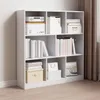 A white, multi-compartment bookshelf filled with books and boxes. Produktbild-Vorschau