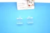 Two clear plastic window hooks and a product package with branding and text are laid out on a light blue background. Produktbild-Vorschau