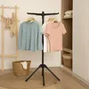 A drying rack with clothes is shown in a room with a basket and a wooden rack. Produktbild-Vorschau