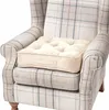 A cream-colored seat cushion is placed on a plaid armchair. Náhled obrázku produktu