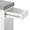 A close-up view of a white wooden shoe bench with a gray upholstered seat, showing an open drawer with a wooden trim and a screw. Produktbild-Vorschau