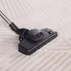 A close-up of a vacuum cleaner head on a carpet. Produktbild-Vorschau